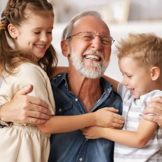 A happy grandfather hugging his grandchildren